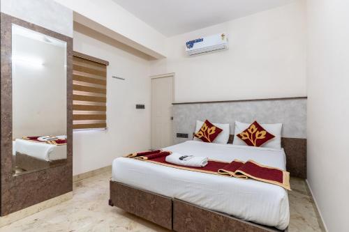 a bedroom with a large bed and a mirror at Hotel metro grand in Bangalore
