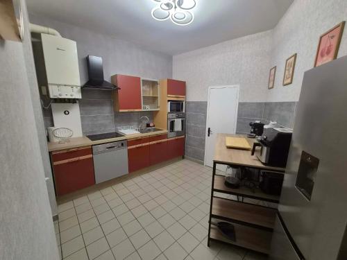a kitchen with red and white cabinets and appliances at Petunia in Commentry