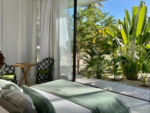 a bedroom with a bed and a large window at Le rêve des kitesurfeurs in Itarema