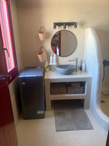 a bathroom with a sink and a mirror at Stone Wave Kythnos in Loutra