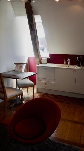 a kitchen with a red chair and a table at La Maison des Courtines in Beaune