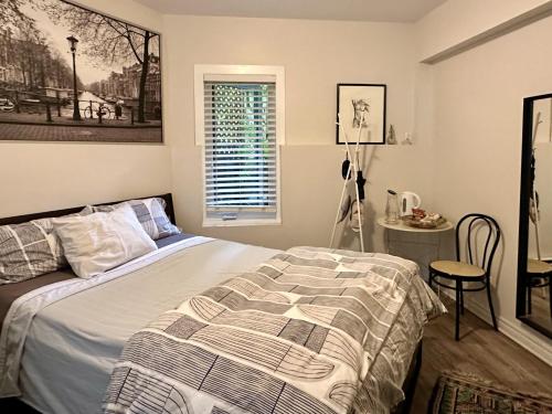 a bedroom with a bed and a table and a window at A Gem Downton Montreal in Montreal