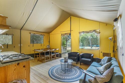 a living room with a couch and a table at Glamping - Quinta do Cascalhal in Arco de Baúlhe