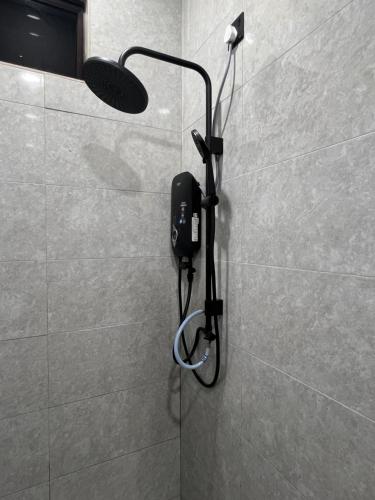 a shower with a phone on a wall in a bathroom at Luminara Villa Kuala Besut in Kampung Kuala Besut