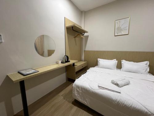 a hotel room with a bed and a mirror at Luminara Villa Kuala Besut in Kampung Kuala Besut