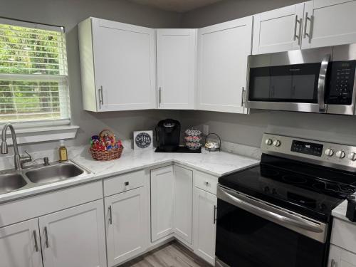 a kitchen with white cabinets and a black appliance at Cherry Cottage in Lake City