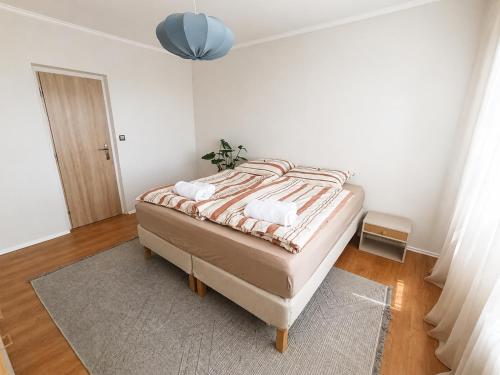a bedroom with a bed in a white room at Apartmán Malohont in Rimavská Sobota