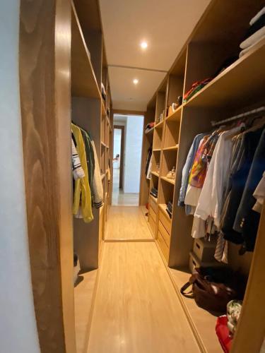 ein begehbarer Kleiderschrank mit Holzregalen und ein Flur in der Unterkunft Ess in Casablanca
