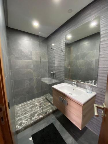 ein Badezimmer mit Waschbecken und Dusche mit Spiegel in der Unterkunft Ess in Casablanca