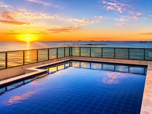 a swimming pool on the deck of a cruise ship at sunset at Praia Dourada SUÍTE ITAPARICA 1206 in Vila Velha