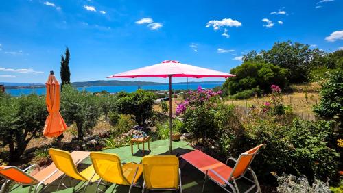a group of chairs and a table with an umbrella at Mendy Sea View Apartment in Kaštela