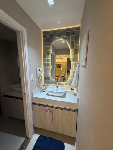 a bathroom with a sink and a mirror at MERCURE RECIFE NAVEGANTES · Flat Recife Navegantes - 50 metros da praia. in Recife