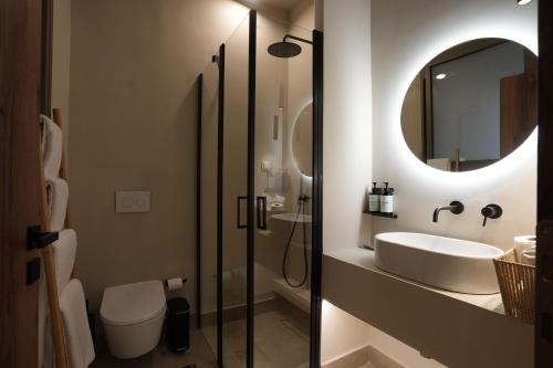 a bathroom with a sink and a toilet and a mirror at Phi Aegina in Agia Marina Aegina