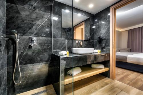 a bathroom with a shower and a sink at Palatino Hotel in Zakynthos