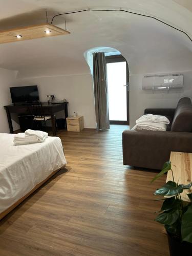 a living room with a bed and a couch at Da Noi Panoramic Guest Stay Camera Rifugio in Cuorgnè