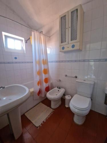 a white bathroom with a toilet and a sink at Casa dos Alpendres in Avis
