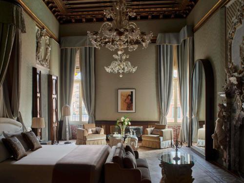 a bedroom with a large bed and a chandelier at Orient Express Venezia in Venice