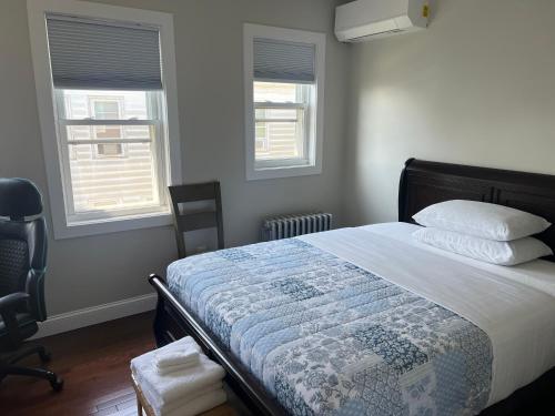 a bedroom with a bed and two windows at Airport room 33 in Boston