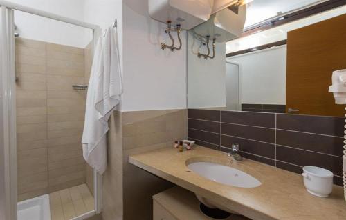 a bathroom with a sink and a shower and a mirror at Giardino del carrubo in Marina di Ragusa