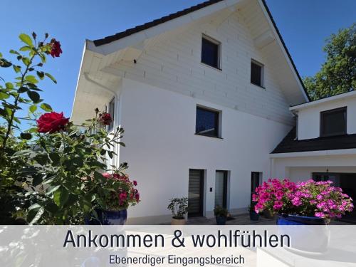 a white house with flowers in front of it at Die Perle am Teich ist Ihre exklusive Ferienwohnung mit Klimaanlage und großer Terrasse im Harz in Ballenstedt