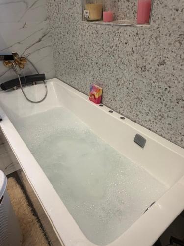 a bath tub filled with water in a bathroom at Le Refuge du Lac Rose in Ouayembame