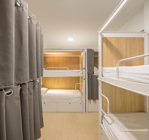 a small room with two bunk beds and curtains at UP Hostel Valencia in Valencia