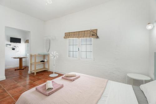 a white room with two towels on a bed at Casa Veronica in Arona