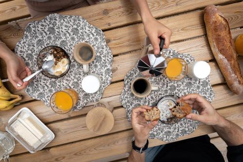 a group of people sitting at a table eating breakfast at Maison de vacances avec cave voûtée entre Lyon et Beaune in Givry
