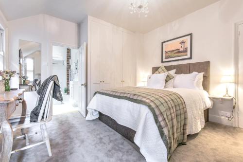 1 dormitorio con cama, mesa y escritorio en April House Weybridge - Boutique Guesthouse en Weybridge