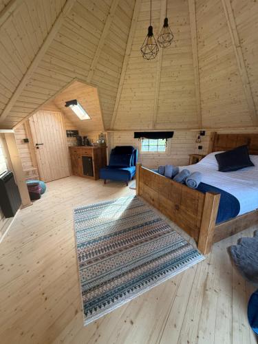 a bedroom with a bed and a blue chair in a room at Press Brook Park in Clay Cross