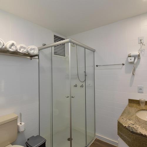 a glass shower in a bathroom with a sink at Apart 1803 - Centro Curitiba in Curitiba