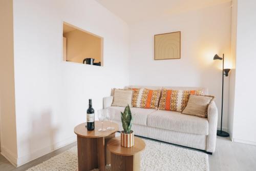 a living room with a white couch and a table at Vue mer, sur le port, près des tours in La Rochelle