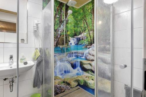 ein Wasserfall-Wandbild in einem Badezimmer mit Duschkabine in der Unterkunft Ferienhaus Heerlichkeit in Löffingen