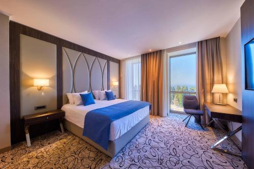 a hotel room with a bed and a desk and a window at EDELWEISS HOTEL El Mouradia in El Mouradia
