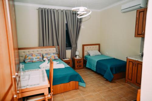 a bedroom with two beds and a window at Vila BENE in Pogradec