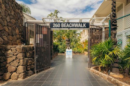 a gate to a resort with a beachwalk sign at Waikiki Heritage Hotel in Honolulu