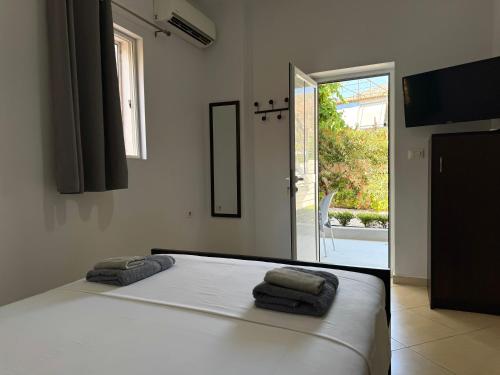 a bedroom with a bed with two towels on it at Tomi garden apartment in Sarandë
