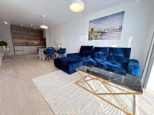 a living room with a blue couch and a table at Anna Lakeside Apartman in Gárdony