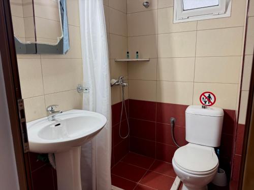 a bathroom with a toilet and a sink at Tomi garden apartment in Sarandë