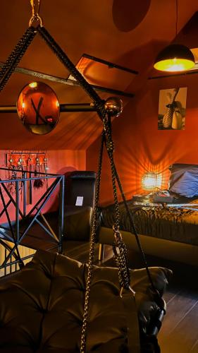 a room with a bed and a swing at Love Room SPA l'impertinente in Isbergues