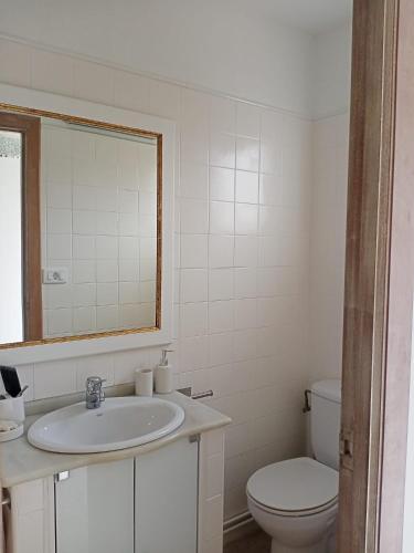 a white bathroom with a sink and a toilet at Casa de Concha in Burela de Cabo