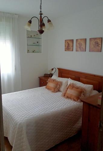 a bedroom with a white bed with two pillows at Casa de Concha in Burela de Cabo