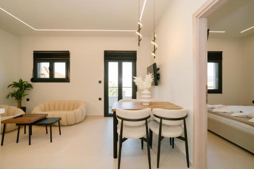 a dining room and living room with a table and chairs at Aether Home in Ammoudia