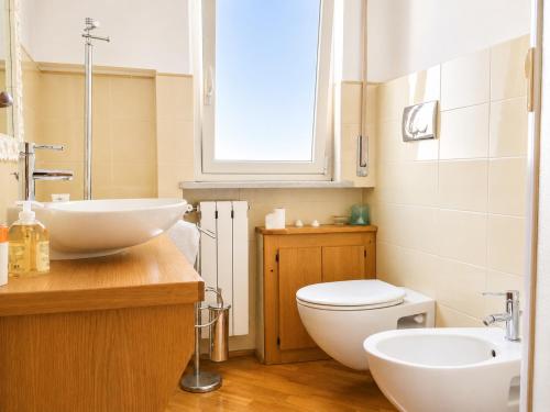 a bathroom with two sinks and a toilet and a window at il grippiale in Aci Castello