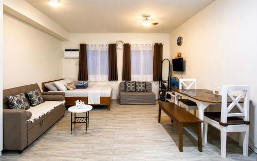 a living room with a couch and a table at Nuvali Studio Retreat Free Parking Fast WiFi Pool in Calamba