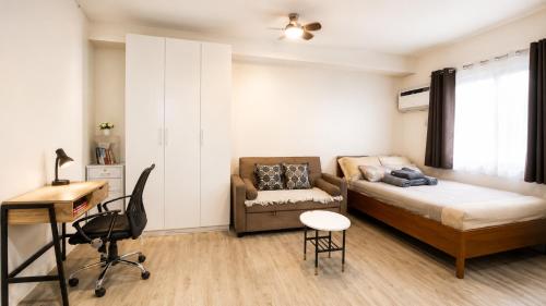 a bedroom with a bed and a desk and a chair at Nuvali Studio Retreat Free Parking Fast WiFi Pool in Calamba