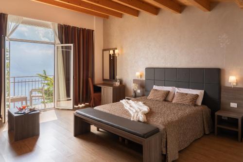 a bedroom with a large bed and a balcony at Village Hotel Lucia in Tremosine Sul Garda