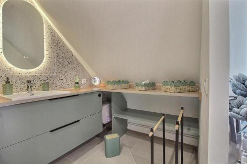 a bathroom with a sink and a mirror at Les Gîtes Shu-no in Pléhédel