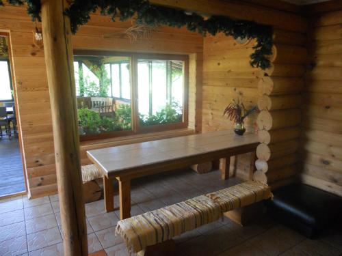 a wooden room with a table and benches in a cabin at Viesu māja Forrest in Dzimtmisa
