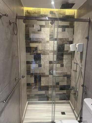 a shower with a glass door in a bathroom at Kmt Hostel in Cairo